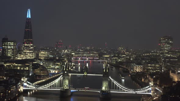 Slow circling drone shot of lit up Tower Bridge London at night