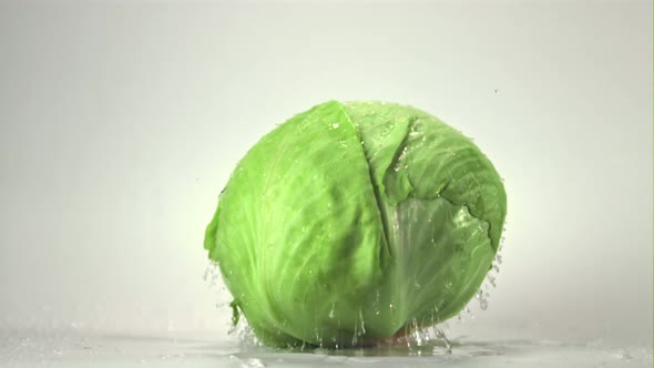 Super Slow Motion of the Fork Cabbage Falls on the Table with Drops of Water