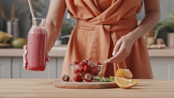 Unrecognizable Woman Taking Strawberry in Kitchen