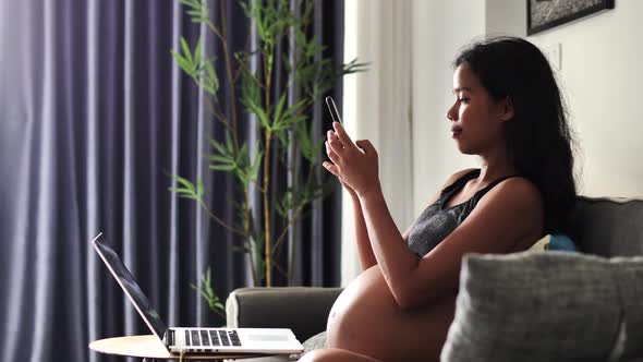 Pregnant Woman Sitting on the Sofa Taking Selfie and Photos of Her Big Tummy