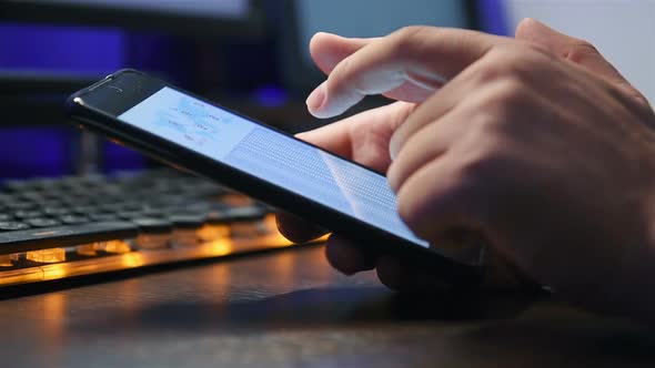 Businessman Using Phone With Financial Data