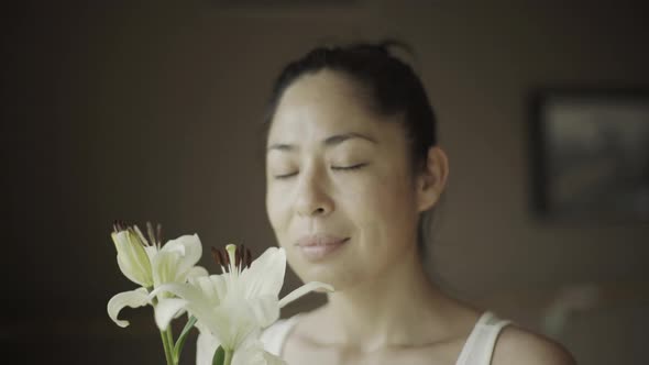 Woman smelling lilies, portrait