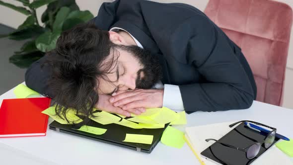 Exhausted and Tired Businessman Sleep with His Head Computer