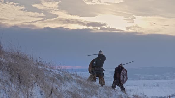 Two Viking Are Fighting with Axes and Shields on the Winter Meadow.