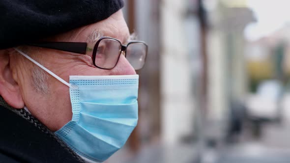 Old Grandfather in a Protective Mask Against Coronavirus