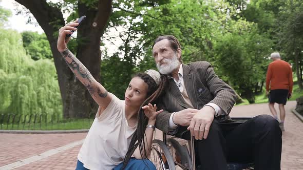 Modern Young Girl with Dreadlocks which Making Selfie Together with Her Handsome Granddad