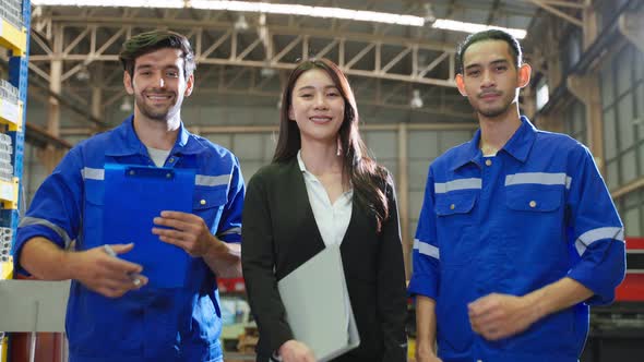 Portrait of industrial man worker and businesswoman working in factory.