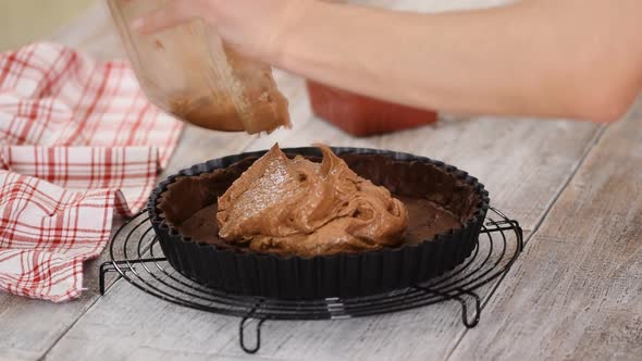 The pastry chef makes chocolate almond cake with almond cream.