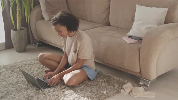 Biracial Girl Texting with Friends on Laptop from Home