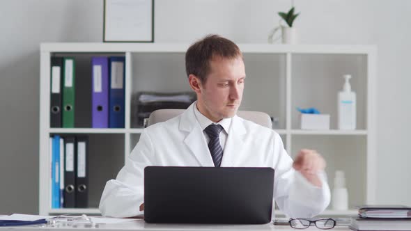 Professional medical doctor working in hospital office using computer technology.