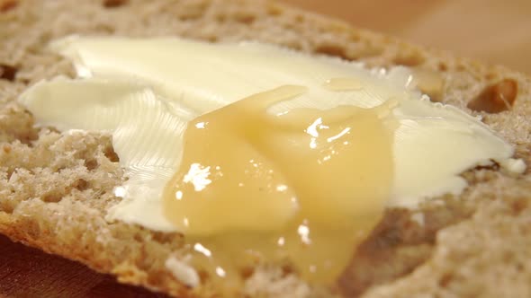 Pouring applesauce on a sandwich with butter. Splashing apple puree. Macro shot. Breakfast dessert