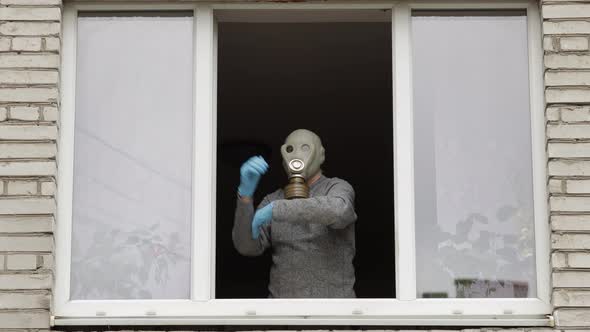 Old Man in Gas Mask Dance at Window Isolated at Home on Quarantine. Coronavirus