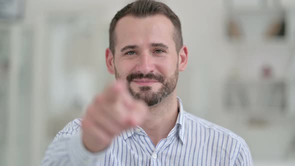 Portrait of Young Man Pointing at the Camera with Finger 