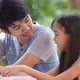 Little Asian girl with father doing homework on the table. - VideoHive Item for Sale