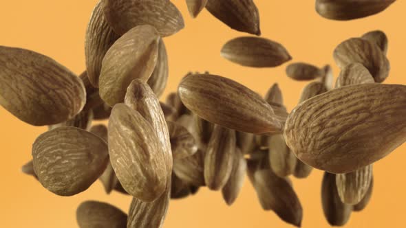 Flying of Almonds in Pale Orange Background