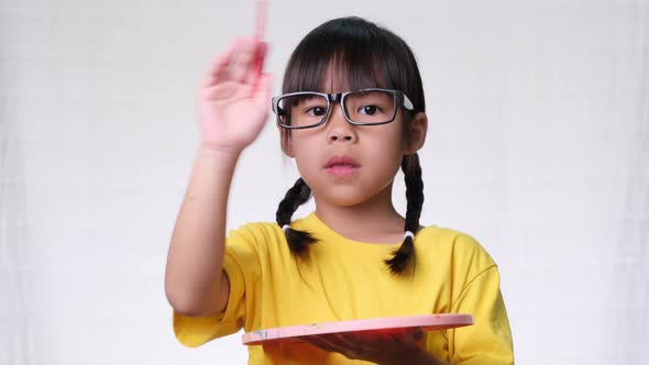 Cute little girl holding a brush painting an imaginary alt
