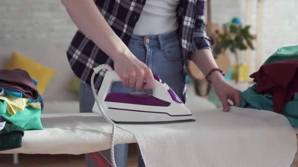 Female Hands of Housewife Ironing Closeup Indoor