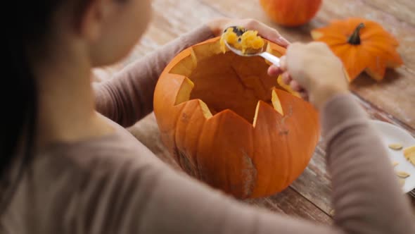 Woman Carving Halloween Pumpkin