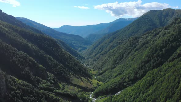 Aerial: drone flying over scenic waterfall and mountain stream on the italian Alps