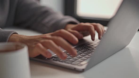 Male hands typing by laptop