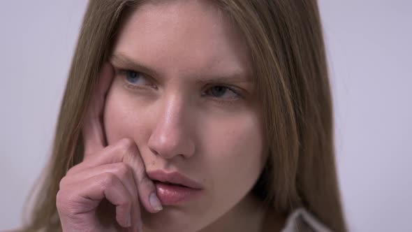 Close-up Portrait of Pretty Confident Thoughtful Girl, Holding Hand Near the Face, Looking Seriously