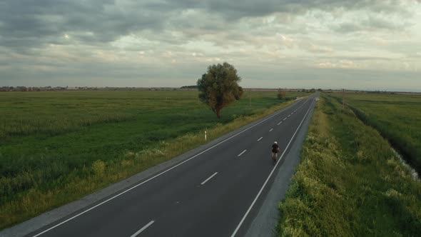 A Cyclist is Riding Slowly Along the Highway