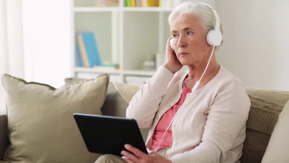 Senior Woman with Tablet Pc and Headphones at Home