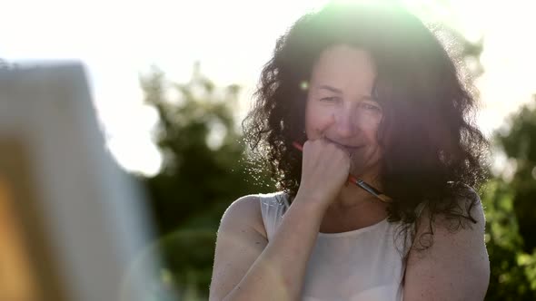 Female Artist Painting a Colorful Painting Outdoors