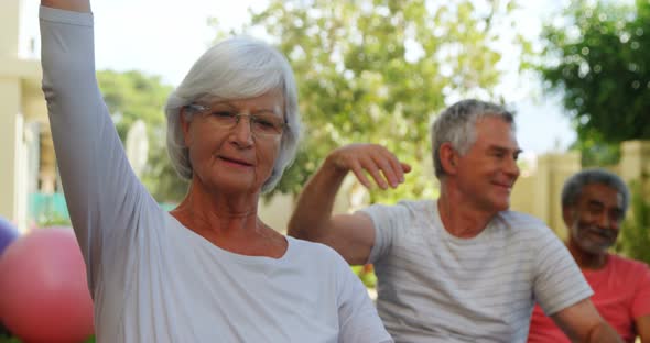 Senior friends doing exercise in garden 4k