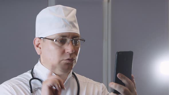 a doctor in uniform with a stethoscope talks to a patient in a video chat application, video confere