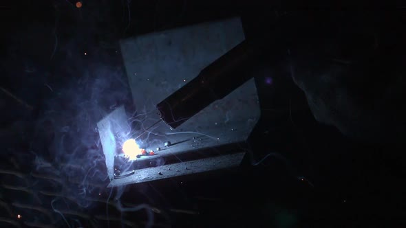 Slow motion of arc welder up close.