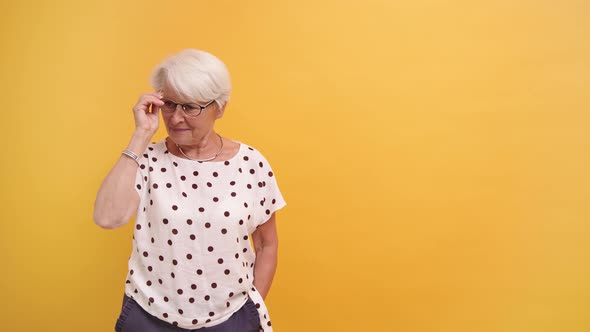 Confident Senior Woman Removing Glasses and Bitting the Temples