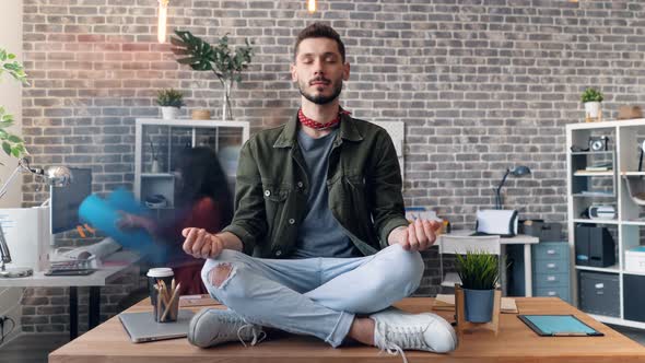 Time-lapse of Employee Meditating in Lotus Position on Office Desk at Work