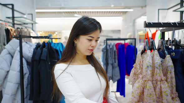 Asian Woman at Clothes Store Looking for Apparel