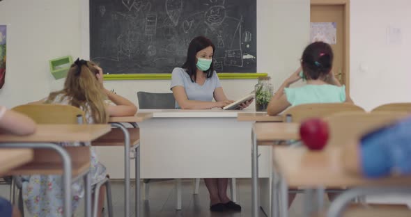 Female Teacher Wearing Face Mask at School Teaching Children at School Classroom
