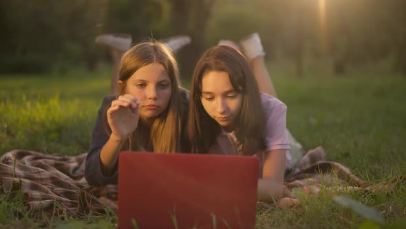 Two Positive Teenage Girls Closing Laptop Running Away Leaving in Golden Sunshine in Slow Motion