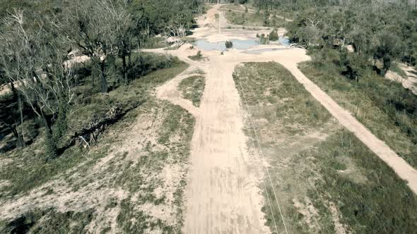 Drone aerial footage of telephone lines along a dirt road in regional Australia