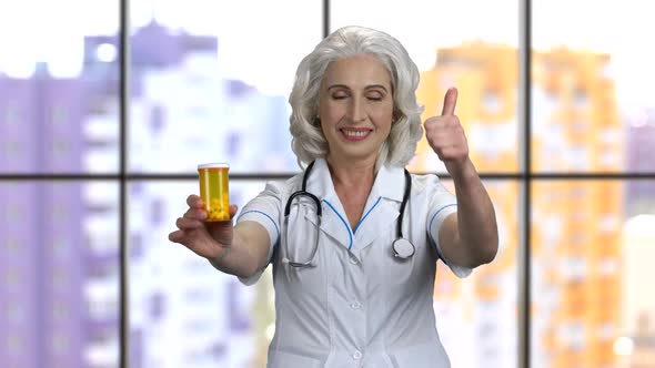 Senior Woman Doctor Shows Can of Pills and Thumb Up