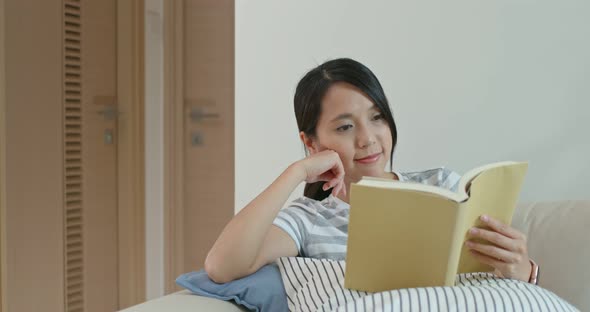 Woman Read on Book and Sit on Sofa at Home