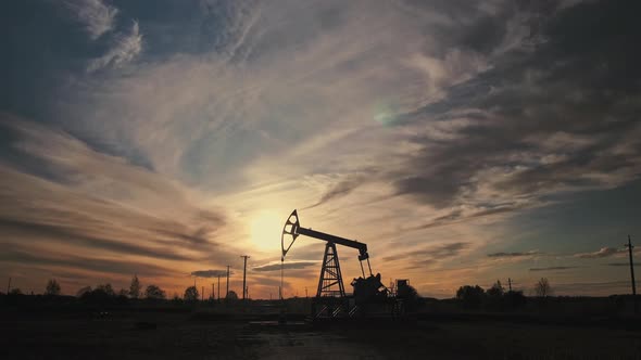 Oil pump oil rig energy industrial machine in the sunset