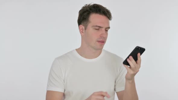 Angry Young Man Talking on Phone on White Background