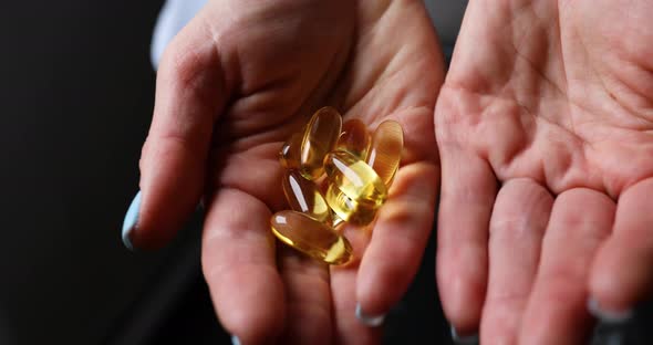 Woman hand holding an omega 3 Fish oil capsules