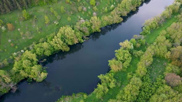 View of the river from above. Flight over water and forest trees from a height