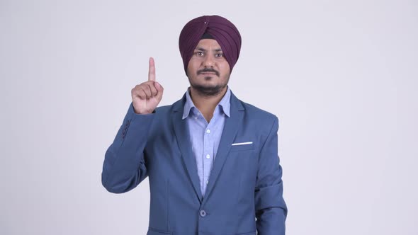 Happy Bearded Indian Sikh Businessman Pointing Up