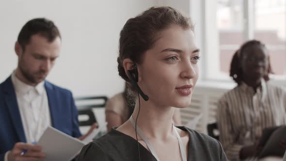 Businesswoman in Headset Looking and Smiling