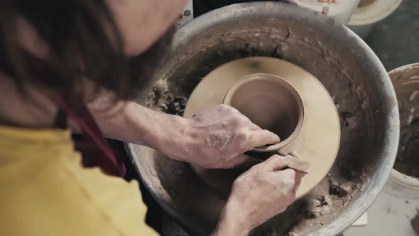 Hands of the Master Potter and Vase of Clay on the Potter's Wheel Closeup