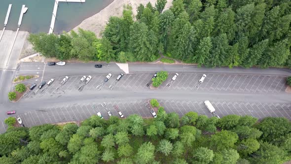 Aerial top down view following an SUV with boat trailer at the lake.