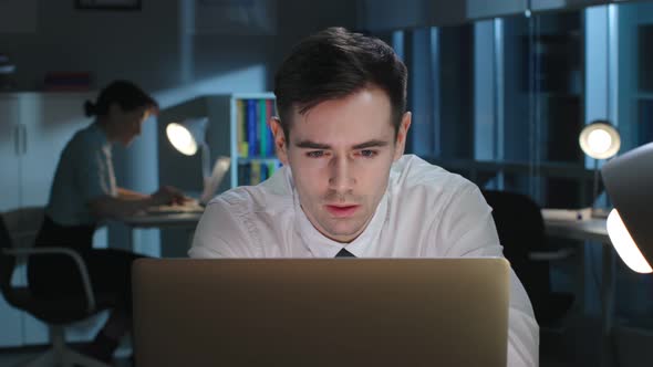 Young Manager Work on Laptop and Read Good News Late in Dark Office