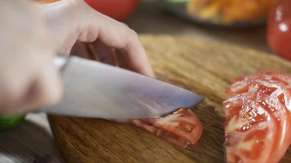 Close Up Shot of Culinary Master is Cutting Tomato to Be Prepared As a Cooking Ingredient