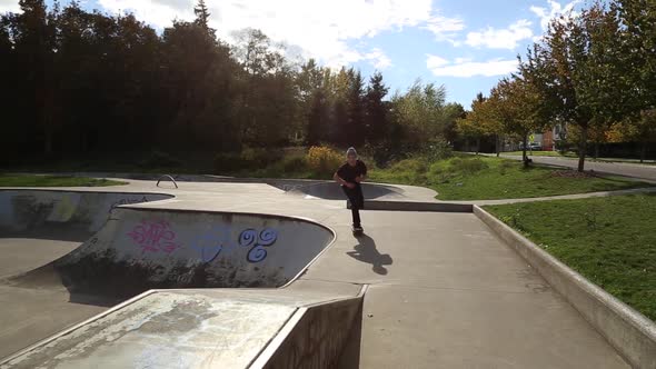 A young skateboarder going off ramps at a skate park.